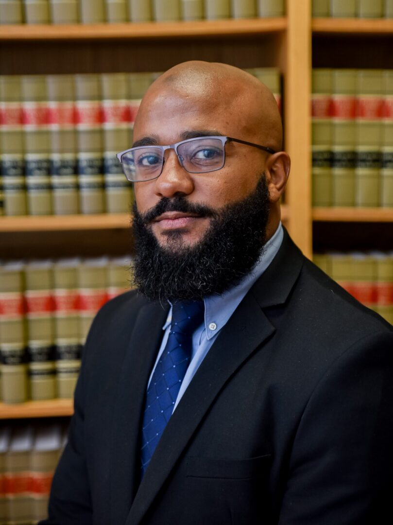 Bearded professional in suit by law books